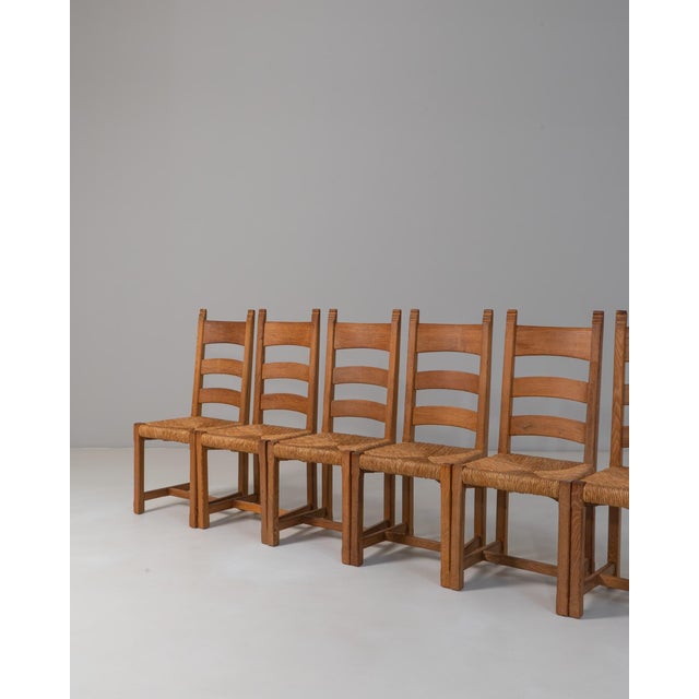 This Set of Six 20th Century French Provincial Oak Ladder-Back Dining Chairs reflects the honest craftsmanship and...