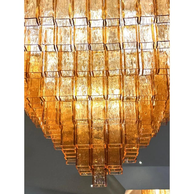 Elegant luxury flush mount made in amber-rosè murano glass “squared” elements. “squared ” are blown inside a wooden mold,...