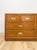 This vintage lowboy dresser by Dixie showcases the clean, tailored silhouette of classic campaign-style design, finished...