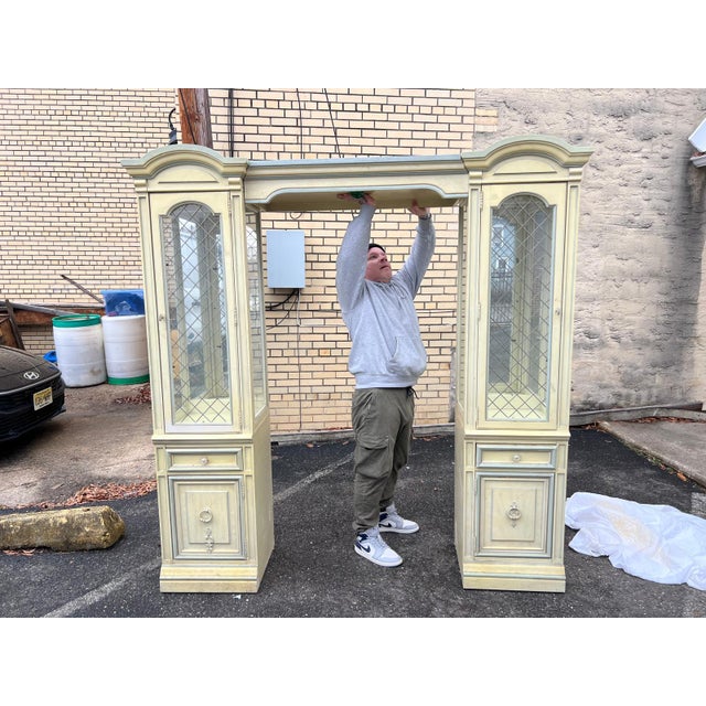 Elegant china cabinet wall unit crafted circa 1980s in the French Provincial style, featuring a beautifully painted...