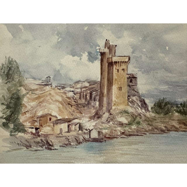 Original watercolor on paper depicting a fortified tower or castle beside a body of water, with adjoining buildings, rocky...