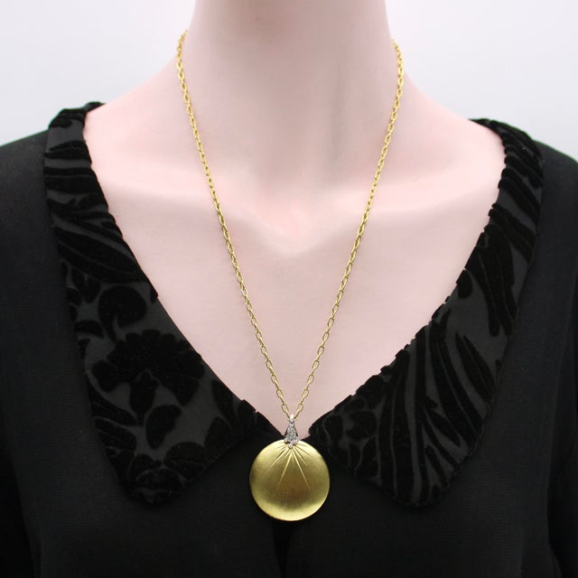 This 18k gold diamond disc pendant has a hand-done Florentine surface and beautiful engraved starburst pattern on both...