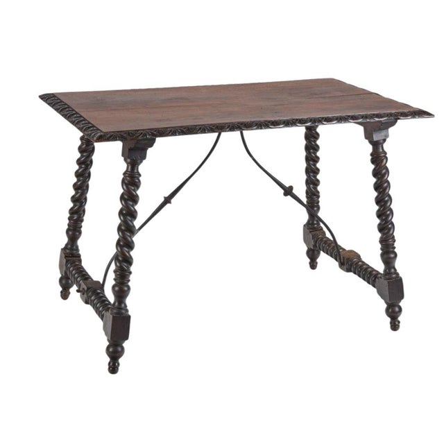 This Spanish Baroque style center table, crafted in the late 19th century, features a robust carved walnut base and...