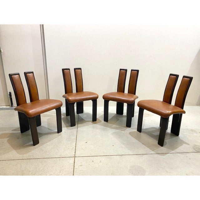Set of 4 chairs from the 80s, dark brown lacquered wooden frame, brown leatherette lined upholstery.