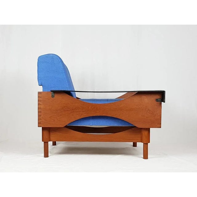 Pair of armchair with teak and skai frame and light blue fabric covering. All cushioned parts such as the backrest, the...