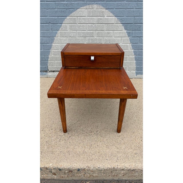 American of Martinsville walnut step end table, circa 1960s, showcasing the brand’s signature balance of clean lines and...