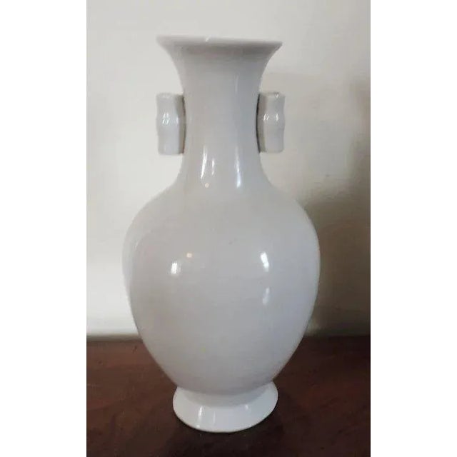 Vintage Chinese porcelain vase in white blanc de chine glaze. Art Deco Styling. Baluster shape with bamboo ears to the...