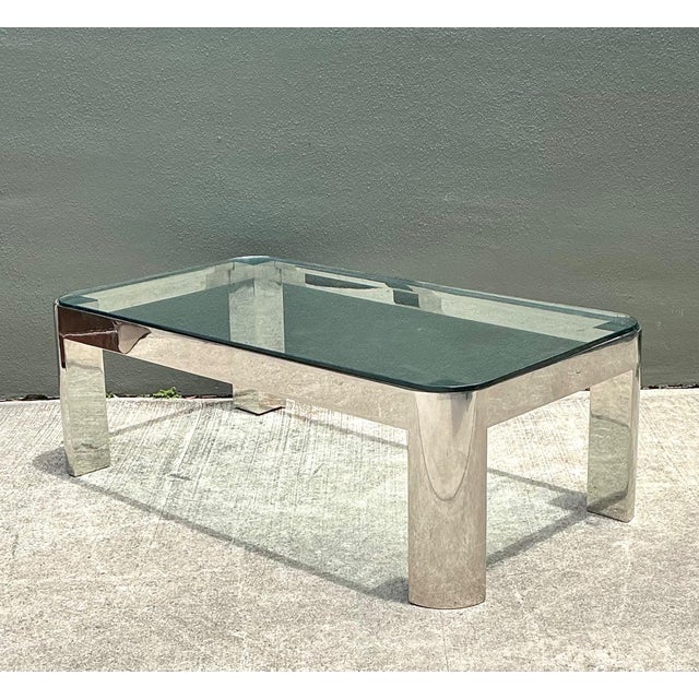 This elegant vintage chrome and glass coffee table draws inspiration from the refined modernist aesthetic associated with...