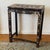Antique Chinese black lacquer accent table featuring hand-painted floral decoration and a decorative figural scene to the...