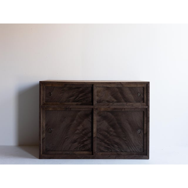 This cha dansu tea cabinet was crafted in Japan during the Taishō to early Shōwa period, using richly grained keyaki...