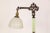 An early 20th-century bridge-style floor lamp of decorative cast iron and yellow-green uranium glass. The top has an...