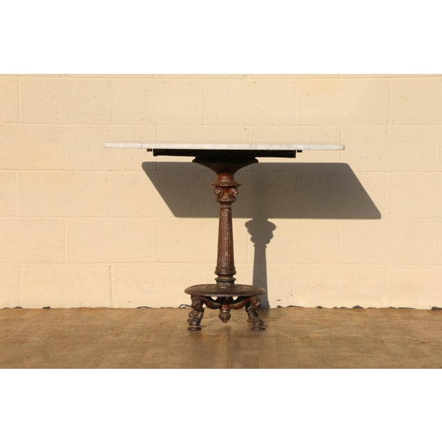 Charming antique French bistro table dating to the early 1900s, featuring a beautiful rectangular marble top with elegant...