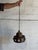 This hanging ceramic pendant lamp showcases a rich brown glazed pottery shade with unique cutout details and a suspending...