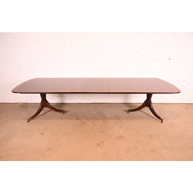 An exceptional Georgian or Regency style double pedestal extension dining table By Baker Furniture USA, Circa Late 20th...
