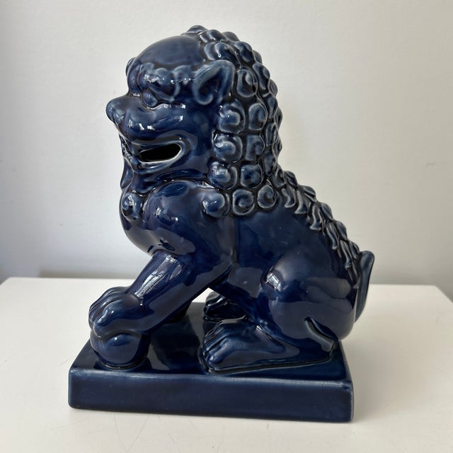 A handsome matched pair of vintage Chinese guardian lions, commonly known as foo dogs, finished in a rich cobalt-blue...