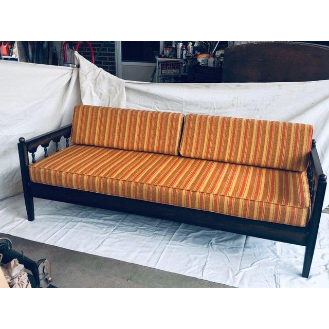 Beautiful 1970 MCM sofa with sold wood frame, multi shades of orange, yellow and brown strips on the cushion and 2 back...