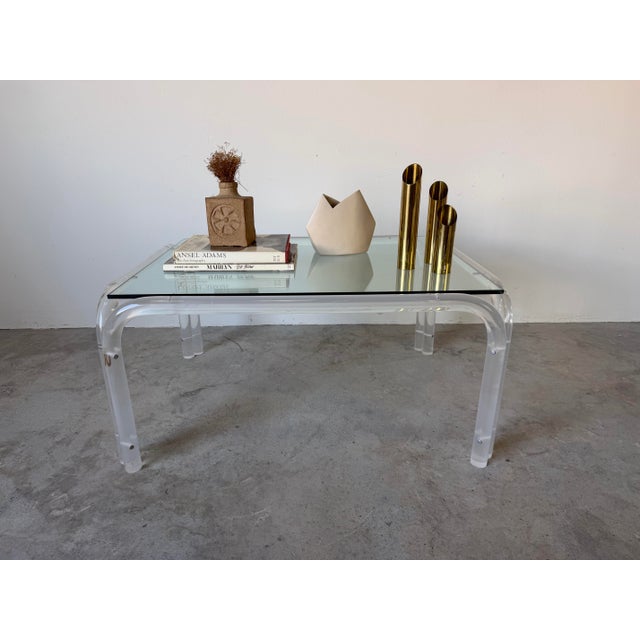 Striking vintage 1970s coffee table featuring a sculptural clear tubular acrylic (lucite) frame paired with a floating...