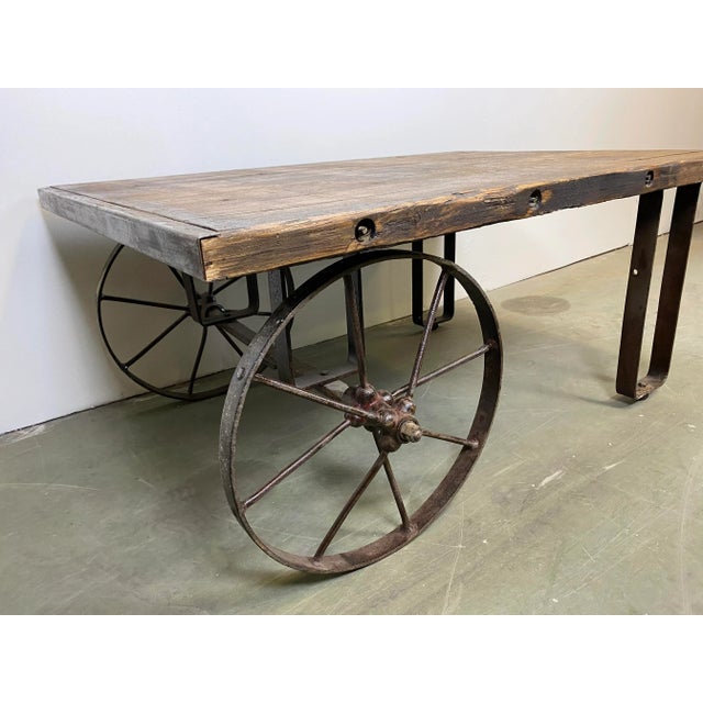 This is an industrial coffee table from the 1950s. It features cast iron legs and a solid old wooden plate with very nice...