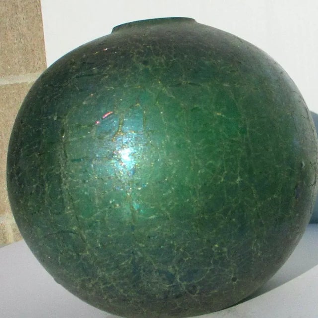 Cast glass green globe with crackle texture and blue-green, red flash glazes. The globe is a great vase and highly...