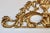 A vintage handmade wall ornament in aged gold gilt, styled after the scrolling acanthus and shell motifs of Italian...