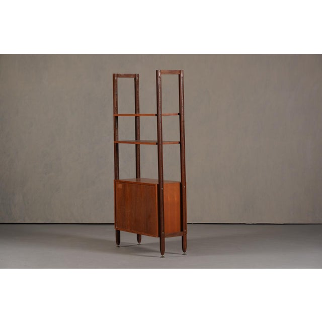 A vintage Italian teak wall unit from the 1960's. The producer and designer are unknown. Made from teak wood with brass...