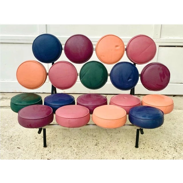 Fabulous vintage multicolored sofa. Retro design that features cushions in pink, orange, purple, blue and green. Inspired...
