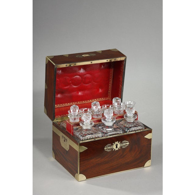 Flamed mahogany liqueur cellar with brass inlaid frame simulating box hardware. The side handles are also inlaid around a...