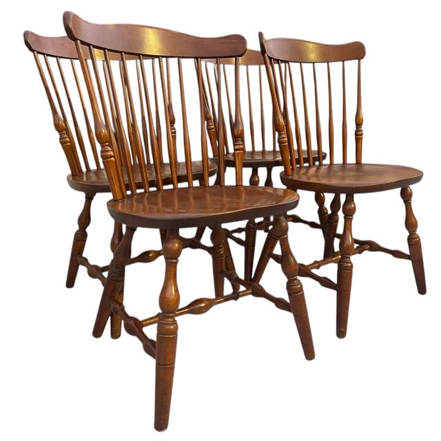 Set of four vintage Windsor dining chairs by S. Bent Bros.. Solid maple construction with sculpted saddle seats, turned...