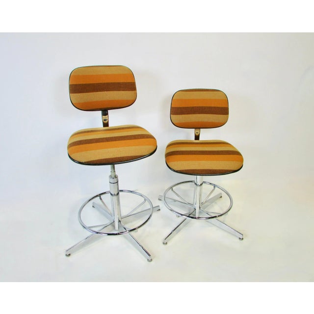 Pair of Steelcase co. operator stools. Upholstered in Alexander Girard attributed brown and gold striped textile....
