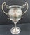 This Victorian silver plated trophy cup features intricate scroll handles and a chased floral design, adding a touch of...