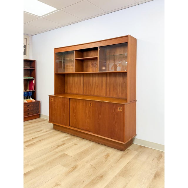 This impressive vintage MCM two piece teak china cabinet is a substantial and beautifully crafted dining room or living...