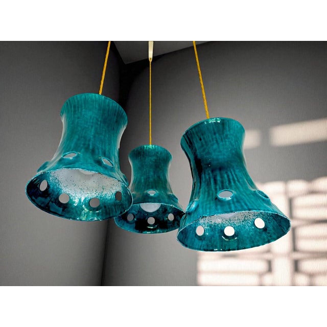 This cascading chandelier was made in Portugal in the 1960s. The lampshades are made of cast iron and painted green on the...