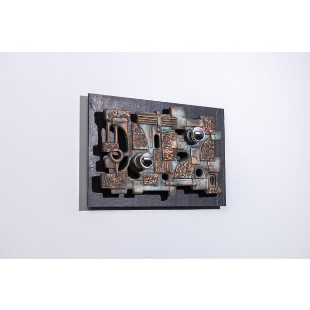 Highly decorative wall lamp by Brakelmann & Becker. This piece is made of a slate slab which holds a ceramic brutalist...