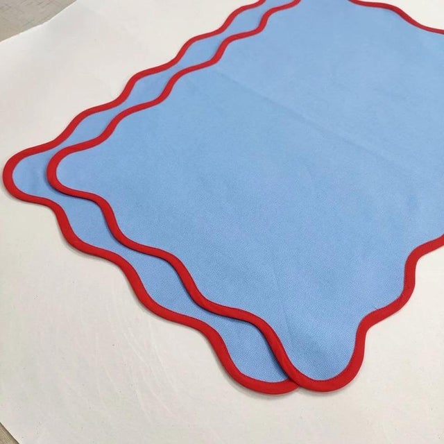 These scalloped placemats have a complimentary color piped around the border - adding a fun twist to your tabletop! Pair...