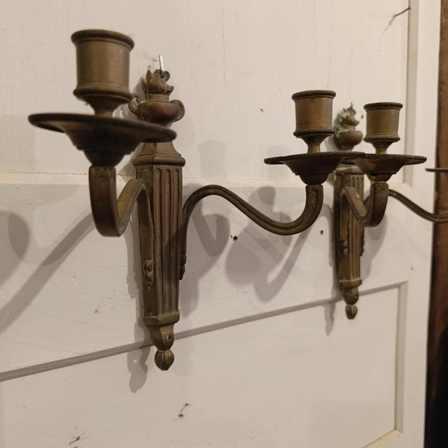Beautiful pair of French bronze wall sconces in Louis XVI / Neoclassical style. These elegant wall sconces feature a...