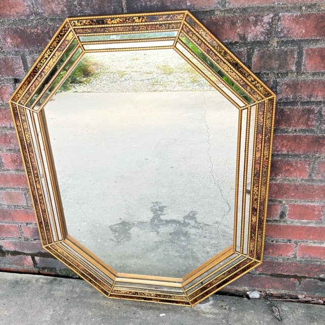 Found in its original vintage condition, this octagonal mirror is a quintessential example of 1970s Hollywood Regency...