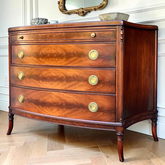 Crafted by White Furniture of Mebane, this elegant bow front chest showcases stunning book-matched crotch mahogany...