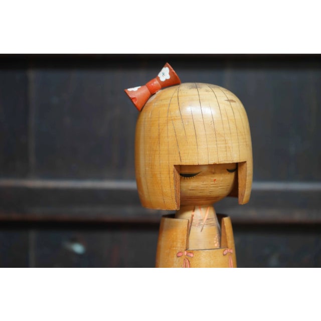 Kawaii kokeshi doll with a beautiful kimono featuring a sakura pattern and a red hair bow. Dimensions: height 26 cm,...