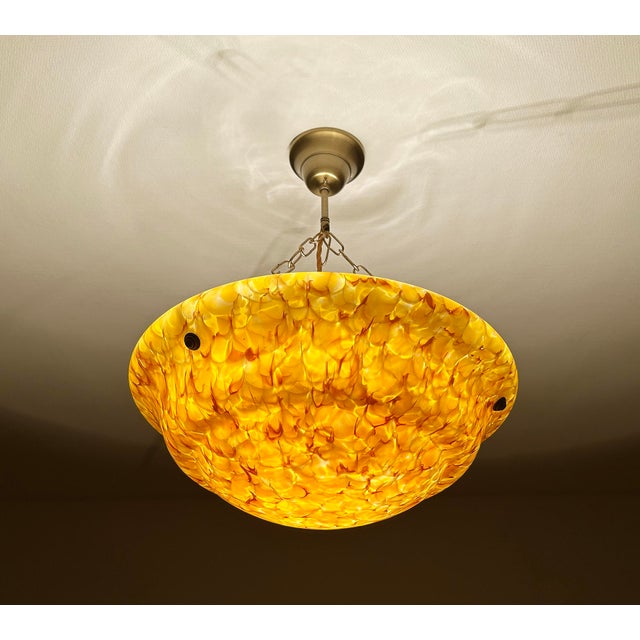 large Art Deco pendant light from the 1930s, with a mottled overlay amber glass shade with fire patterns that comes to...