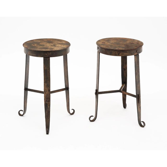 Vintage French side tables or stools made of metal. This pair has the original patina and curved feet at the base of the...