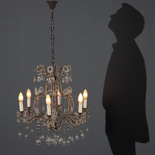 Burnished metal chandelier with scrolls and curls, embellished with glass beading. Six lights supported by curved arms,...