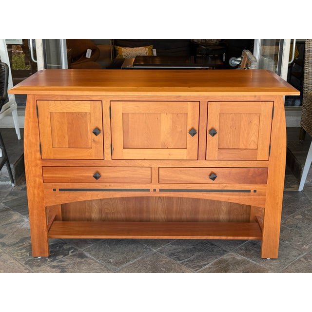 Design Plus Gallery presents the larger Aspen Open Sideboard with Inlay by Simply Amish. Constructed in cherry wood, the...