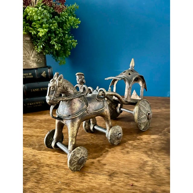 A striking antique cast metal horse-drawn carriage sculpture dating to the early 20th century, circa 1900–1940. This...