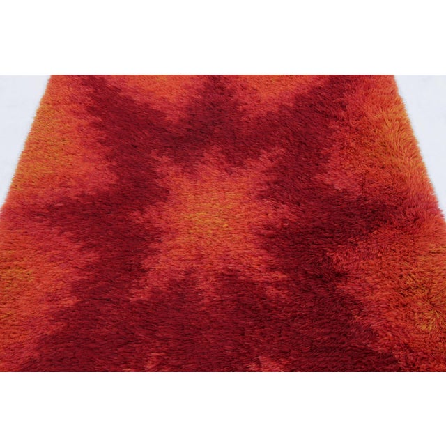Hand-knotted in lush, high-pile wool in Sweden circa 1960-1970, this 5x7 vintage Swedish Rya rug is a bold new addition to...