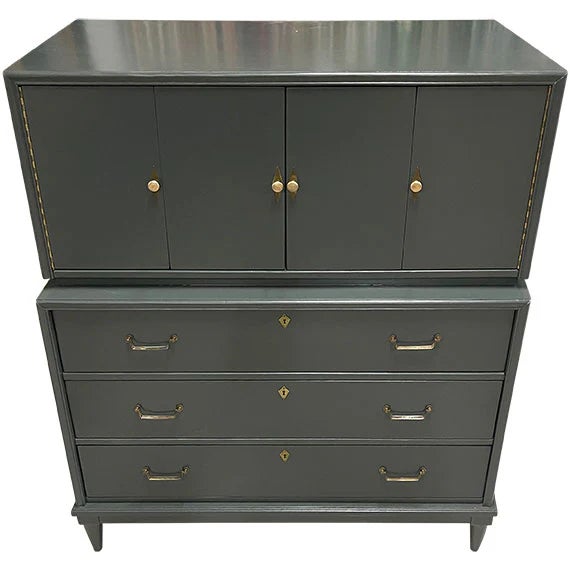Striking and sophisticated, this campaign-style tall dresser blends classic form with bold modern finish. Featuring a two-...
