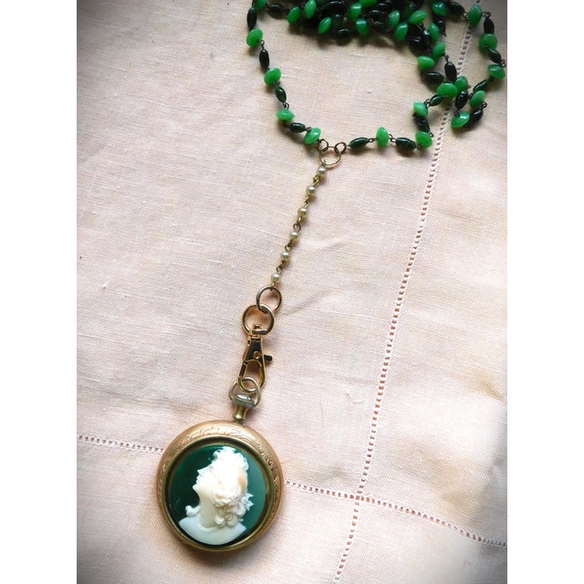 Vintage gold paisley-etched pocket watch locket with green and cream cameo profile of a Victorian woman in rolled-edged...