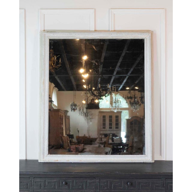 Worked in the Louis XVI taste and made in France in the eighteenth century, this wall mirror has a wood panel frame with...