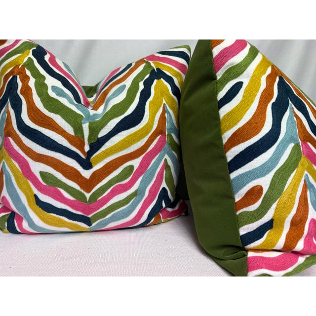 Custom pair of 22" pillows covered in a multi colored, embroidered zebra patterned fabric on a white linen fabric and...