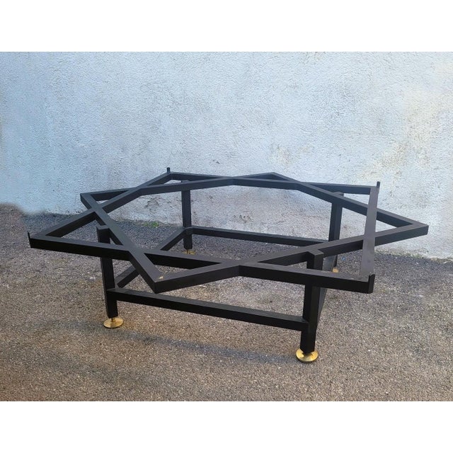 Large coffee table with a black-stained iron base in the shape of a star, topped with a round green onyx tabletop. The...