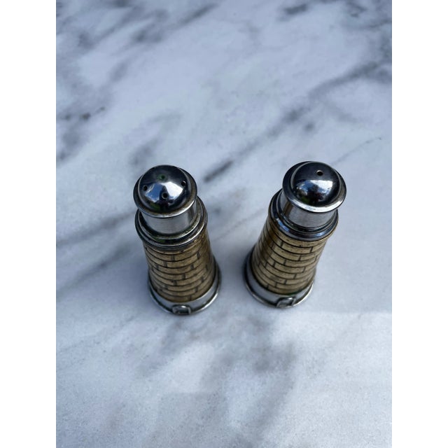 A set of vintage brass and stainless lighthouse salt and pepper shakers. The shakers have a nice weight and feeling in...